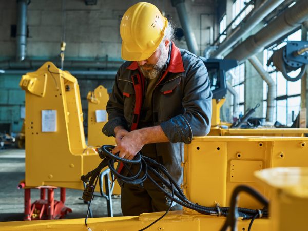 Mature bearded man in uniform examining the new equipment during his work in warehouse